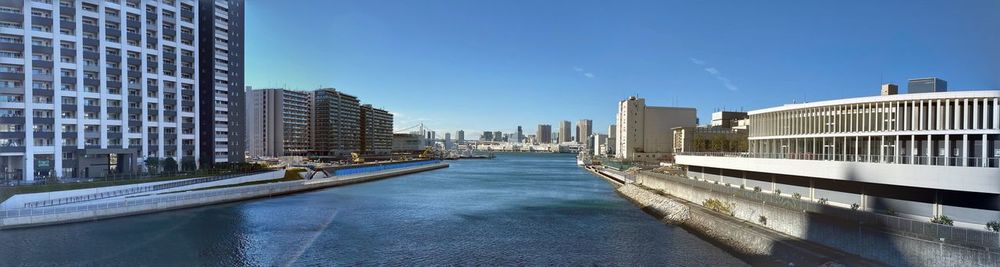 Canal amidst buildings in city against sky