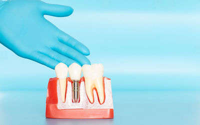 Close-up of hand holding blue over white background