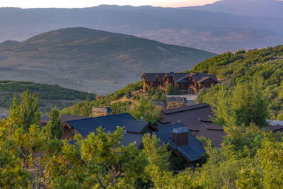 Houses and trees by mountains against sky