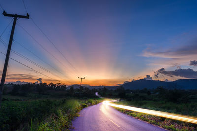 Light trail on road against sky during sunset