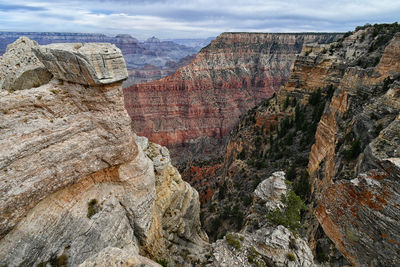 View of rocks and mountains against cloudy sky