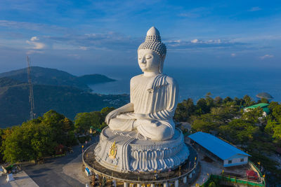 Statue against temple and mountain against sky