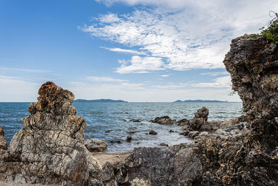 Rock formation on beach against sky