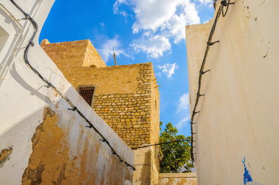 Low angle view of old building against cloudy sky