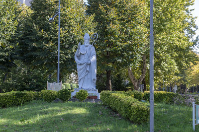 Statue amidst trees in cemetery