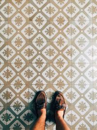 Low section of man standing on tiled floor