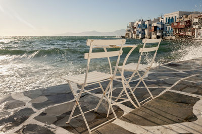Two empty chairs on the waterfront on the island of mykonos, greece. 