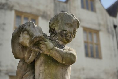 Close-up of angel statue against building