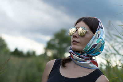 Woman wearing sunglasses and scarf against sky