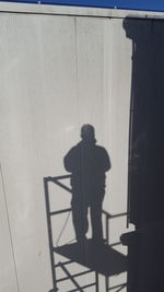 Shadow on man standing at balcony