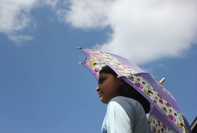 Low angle view of woman looking against sky