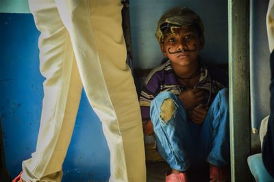 Portrait of boy with face paint sitting at home