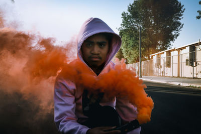 Portrait of man standing with smoke bomb