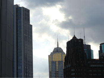 Buildings in city against cloudy sky