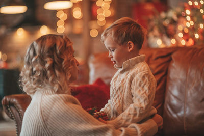 Portrait of happy family mom with small son in knitted beige sweaters