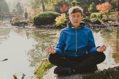 Rear view of boy sitting in water