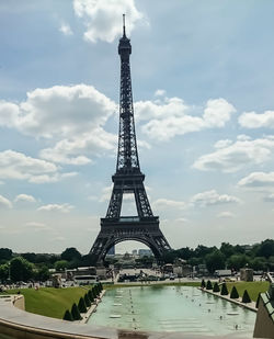 Tower in city against cloudy sky