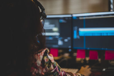 Rear view of woman using computer