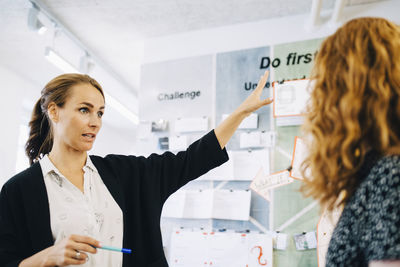 Confident female entrepreneurs discussing over strategy at creative office