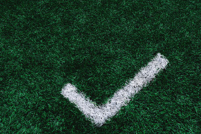 High angle view of check mark sign on grass