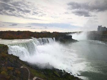 Scenic view of waterfall against sky