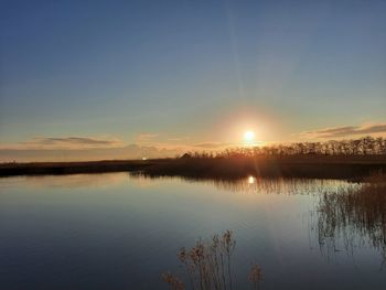 Scenic view of lake against sky during sunset