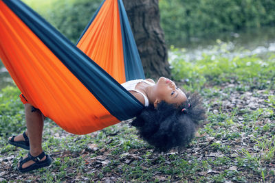 Rear view of woman lying on hammock