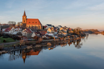 Buildings in town against sky during sunset