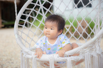 Portrait of cute baby girl looking through fence