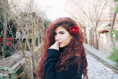 Portrait of beautiful woman standing against tree