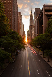 Road amidst buildings in city against sky