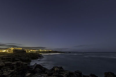 Scenic view of sea against clear sky at night