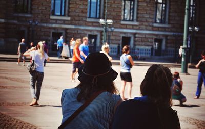 Rear view of people standing in city