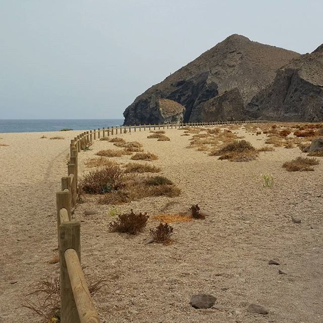 beach, sea, sand, water, horizon over water, tranquil scene, tranquility, shore, scenics, clear sky, beauty in nature, nature, sky, mountain, coastline, incidental people, idyllic, remote, non-urban scene, day