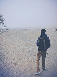 Rear view of man standing on beach