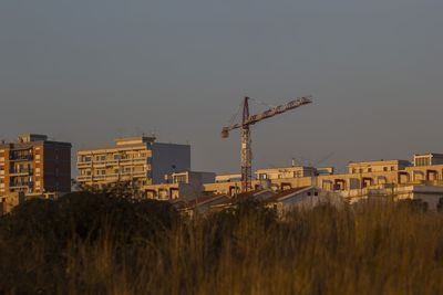 Construction site by buildings against sky in city