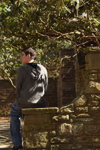 Woman standing on tree trunk