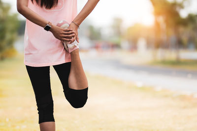 Low section of woman exercising in park
