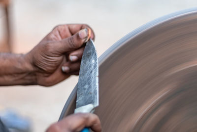 Cropped image of man sharpening knife