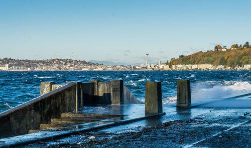 Waves crash onto the shore at alki beach in west seattle, washington.