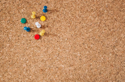 Close-up of colorful thumbtacks on board