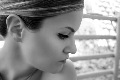 Close-up of beautiful woman with eyeshadow against railing