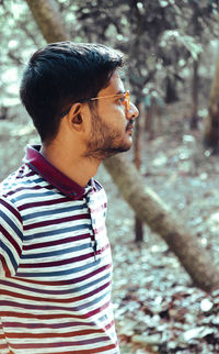 Young man looking away in forest