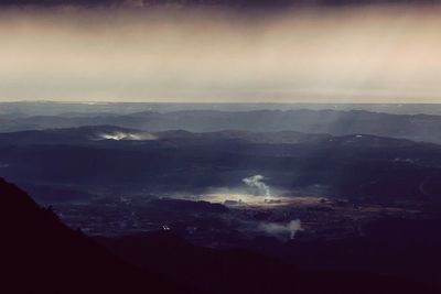 Scenic view of mountains against cloudy sky
