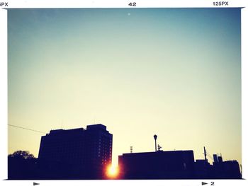 Low angle view of silhouette buildings against clear sky at sunset