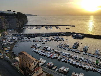 High angle view of boats moored at harbor during sunset