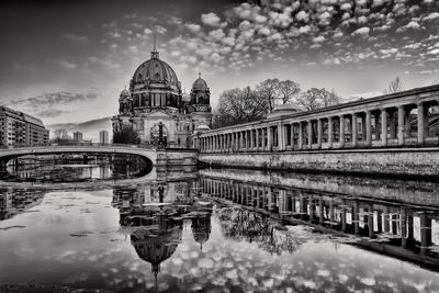 Reflection of church in river against sky