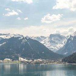 Scenic view of lake and snowcapped mountains against sky