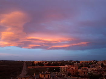 Houses in town against sky during sunset