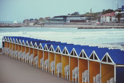 Row of houses by sea against buildings in city